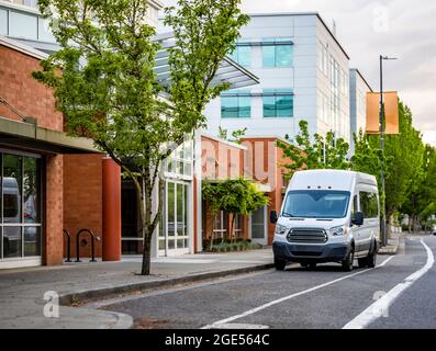 Mini furgone bianco compatto industriale di piccole dimensioni con tetto alto per una comoda consegna locale e piccole esigenze aziendali in piedi sulla strada urbana con Foto Stock