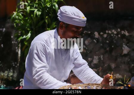 Indonesia, Bali. I sacerdoti indù benedicono adoratori e devoti con acqua Santa durante una cerimonia del festival del tempio in Indonesia, Bali, vicino Ubud Foto Stock