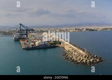 Le acque di breakwater per il porto di Akrotiri, Limassol, Cipro. Limassol Cruise Terminal edifici e gru a portale in background. Foto Stock