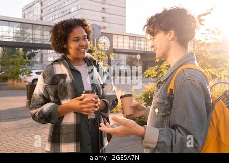 Due studenti di college che hanno bevande dopo le lezioni in ambiente urbano Foto Stock