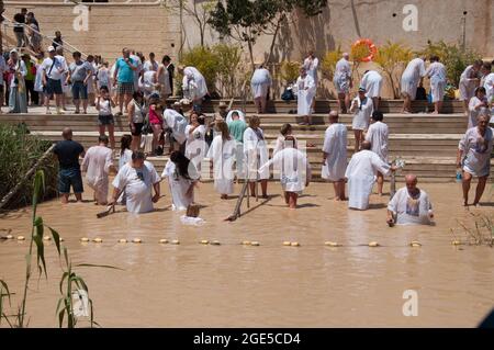 Cristiani che nuotano e sono battezzati nel fiume Giordano, Betania, Giordania, Medio Oriente Foto Stock