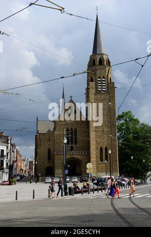 Belgi e turisti che si godono seduti all'aperto con un bicchiere di birra presso la chiesa di Sainte-Sainte-Croix in piazza Flagey. Foto Stock