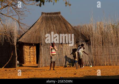 Capanne con tetto in paglia e persone provenienti dalla striscia di Caprivi, Namibia Foto Stock