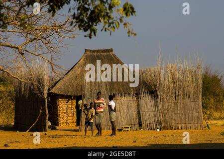 Capanne con tetto in paglia e persone provenienti dalla striscia di Caprivi, Namibia Foto Stock