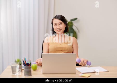 Donna incinta che lavora da casa Foto Stock