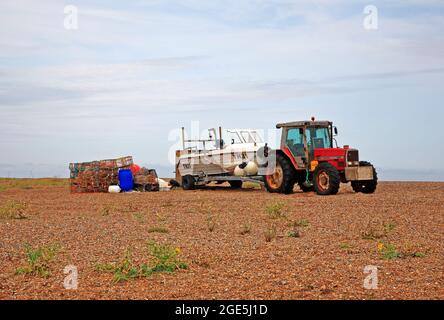 Imbarcazioni da pesca costiera con trattori, rimorchi e attrezzature, con bordo sopra il marchio di alta acqua a Cley-next-the-Sea, Norfolk, Inghilterra, Regno Unito. Foto Stock