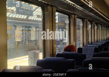 Berlino, Germania. 12 agosto 2021. Un singolo passeggero si affaccia da una finestra dell'IC 2949 sulla pista quasi deserta della stazione di Spandau. Quasi tutti i passeggeri sono in movimento il primo giorno dopo l'inizio dello sciopero deciso dai membri del sindacato dei macchinisti (GDL) in uno sciopero. Il sindacato richiede la conclusione del contratto collettivo di servizio pubblico per il personale diretto con un aumento salariale del 1.4 per cento al 1° aprile 2021, ma almeno 50 euro in più, così come un hatchet corona di 600 euro nel 2021. Credit: Stefan Jaitner/dpa/Alamy Live News Foto Stock