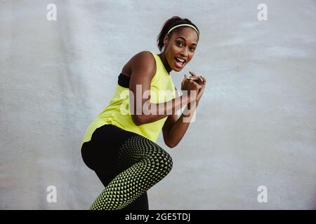 Donna africana in forma fisica che fa un allenamento di kick boxing. donna in forma fisica che fa esercizio alle gambe su sfondo bianco. Foto Stock