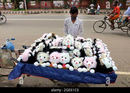 DHAKA, BANGLADESH - 13 AGOSTO: Una persona del Bangladesh, indossa una maschera protettiva mentre offre le figure del teddy ai visitatori sul lato della strada in mezzo alla pandemia di Covid-19. Il 13 agosto 2021 a Dhaka, Bangladesh. Credito: Eyepix Group/The Photo Access Foto Stock