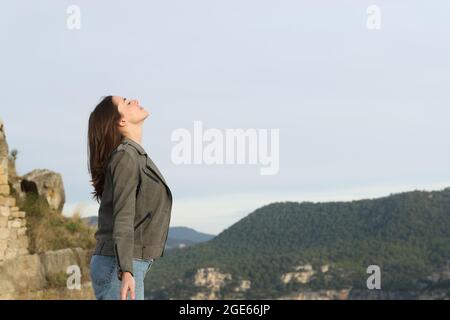 Profilo di una donna casual che respira aria fresca in montagna Foto Stock