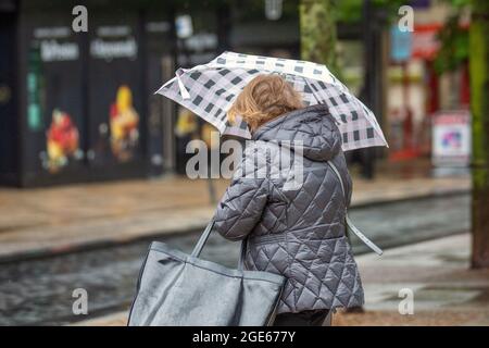 Preston, Lancashire. Regno Unito Meteo. 17 ago 2021. Vendite estive di strade alte, acquirenti e docce a Fishergate. Un'altra doccia umida si estrade giorno nel centro della città, con una previsione di tempo non stagionale per il resto della settimana. Credito; MediaWorldImages/AlamyLiveNews Foto Stock