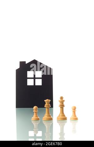 Fotografia concettuale di due pezzi di scacchi bianchi (re e regina) che rappresentano metaforicamente una coppia eterosessuale bianca con due bambini, con la s. Foto Stock