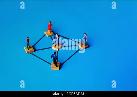Persone in miniatura collegate su cubetti di legno. Concetto di connessione, rete e servizio di social network. Spazio di copia per il testo Foto Stock