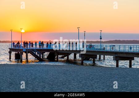 Arcachon (Francia sud-occidentale): I turisti che si godono il tramonto sull'Oceano Atlantico dal molo sulla spiaggia "plage du Moulleau" Foto Stock