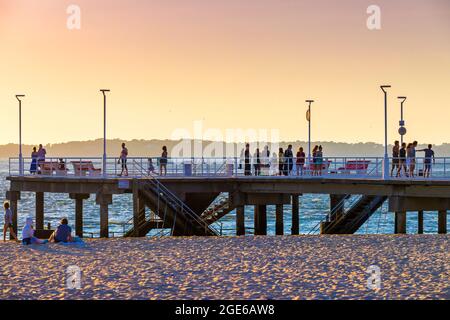 Arcachon (Francia sud-occidentale): I turisti che si godono il tramonto sull'Oceano Atlantico dal molo sulla spiaggia "plage du Moulleau" Foto Stock