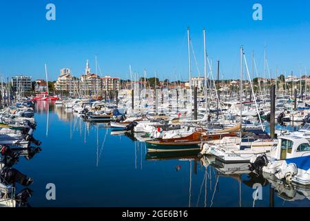 Arcachon (Francia sud-occidentale): Motoscafi e barche a vela nel porto turistico e gli edifici lungo il lungomare Foto Stock