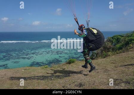 Badung, Bali, Indonesia. 17 agosto 2021. Un parapendio inizia il decollo. La Federazione Nazionale Aerosport (FASI) con l'Aeronautica militare di Bali per la mostra di parapendio porta la bandiera nazionale di 'Merah Putih' (Rosso e Bianco) per commemorare l'Indonesia 76 ° giorno di Indipendenza a Riug Hills, Benoa. La Repubblica di Indonesia proclama il giorno dell'Indipendenza il 17 agosto 1945. (Immagine di credito: © Dicky BisinglasiZUMA Press Wire) Foto Stock