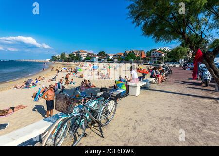 Arcachon Bretagna, Francia nord-occidentale): Folla di turisti sulla spiaggia in estate con case ed edifici lungo il lungomare Foto Stock