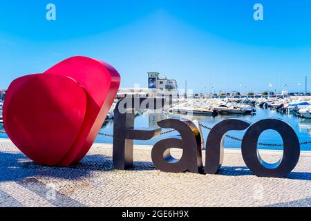 Logo del cartello con il nome Faro di fronte al porto turistico di Faro. I turisti amano scattare foto con questo segno. Faro Algarve Portogallo Foto Stock