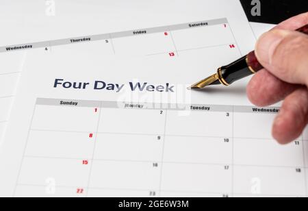 Calendario stampato per una settimana lavorativa di 4 giorni che mostra i giorni del fine settimana in rosso in un nuovo approccio alla produttività Foto Stock