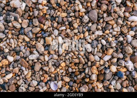 ciottoli colorati pietre piccole sul fiume mare lago riva Foto Stock
