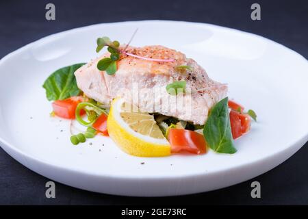 Trota (salmone) con verdure, limone e micrograni, cotti con il metodo confit. Piatto francese tradizionale. Passo dopo passo. Primo piano. Foto Stock