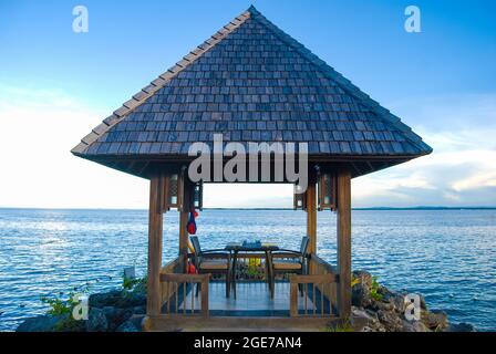 Bordo d'acqua rifugio al tramonto, Shangri-La Island Resort & Spa, Mactan Island, Cebu, Visayas, Filippine Foto Stock