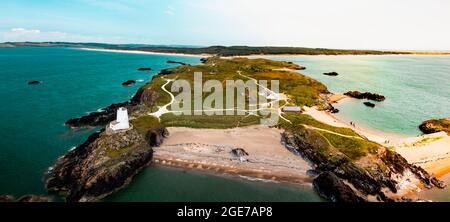 Vista aerea del faro Twr Mawr che significa grande torre in gallese su Ynys Llanddwyn su Anglesey Wales segna l'ingresso occidentale dello stretto di Menai. Foto Stock