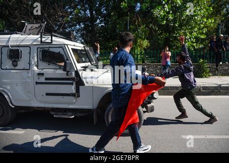 Srinagar, India. 17 agosto 2021. Un Mourner sciita ferma un veicolo blindato durante la processione. Le forze governative hanno fatto ricorso a sparare a pellet, bombardare con gas lacrimogeni pesanti, incaricare di bastone e sparare in aereo contro i musulmani sciiti mentre hanno sfidato le restrizioni in mezzo allo slogan pro-libertà per togliere l'ottava processione Muharram a Srinagar. Credit: SOPA Images Limited/Alamy Live News Foto Stock