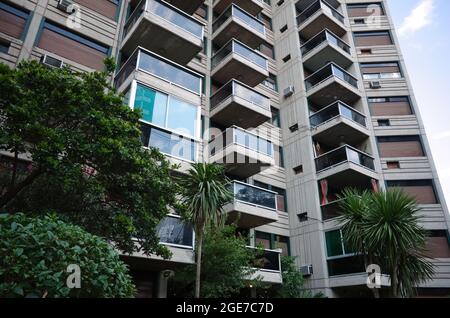 Esterno di un moderno edificio residenziale a piu' piani a Cordova, Argentina, con balconi di vetro e tipiche persiane esterne argentine sulle finestre Foto Stock