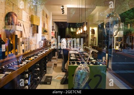 Mendoza, Argentina - Gennaio 2020: L'uomo scarica bottiglie di vino presso il negozio di liquori. Enoteca nel centro della città con il famoso vino argentino a Mendoza Foto Stock