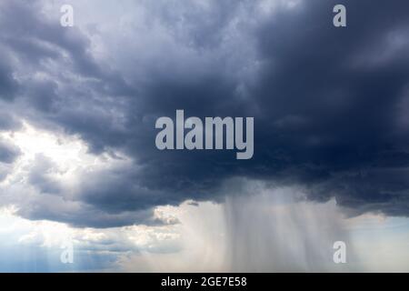 Nuvole scure con pioggia torrenziale . Forte flusso di pioggia da nuvole nere Foto Stock