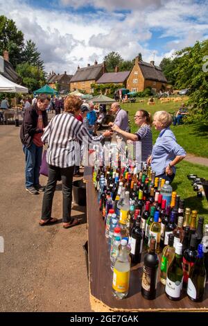 Regno Unito, Inghilterra, Oxfordshire, Wroxton, festa annuale della chiesa in corso, i visitatori al bottle stalle in Main Street, al bordo del villaggio verde Foto Stock