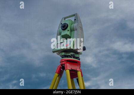 Macchina per topografi con cielo blu e alberi verdi in giorno di sole Foto Stock