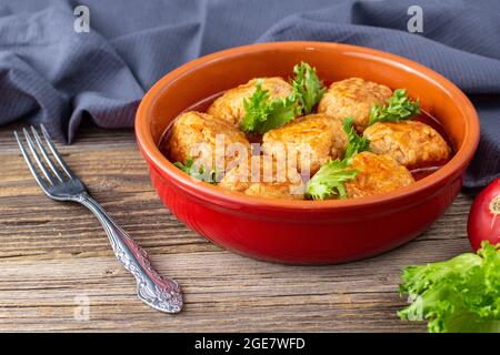 Polpette in salsa di pomodoro in una ciotola su un tavolo di legno. Cibo gustoso per la cena. Foto Stock