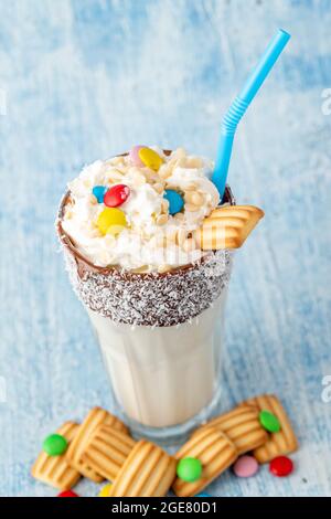 Frullato con latte e biscotto per bambini decorato con zucchero dragato. Foto Stock