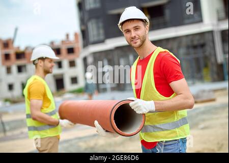 Due operai edili in posizione rigida per la telecamera all'aperto Foto Stock