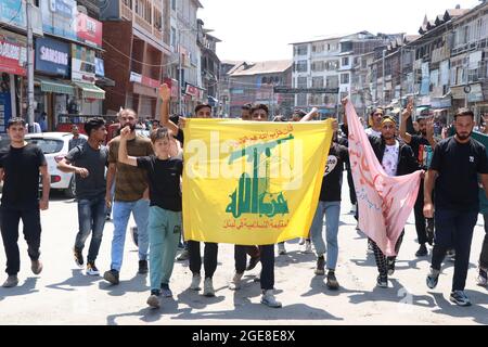 Srinagar, India. 17 agosto 2021. kashmiri Shiite musulmano che porta una bandiera di hizbullah durante la processione religiosa a Srinagar il 17-08-2021. (Foto di Muhammad Manan/Pacific Press) Credit: Pacific Press Media Production Corp./Alamy Live News Foto Stock