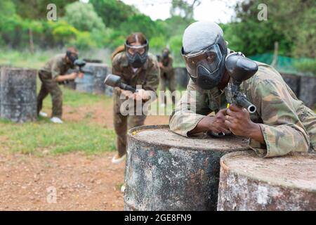 Afro americano uomo paintball giocatore in camouflage con pistola Foto Stock