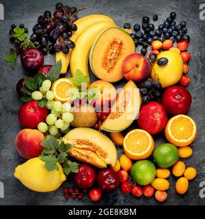 Frutta fresca assortita su sfondo scuro. Concetto di cibo biologico. Vista dall'alto, disposizione piatta Foto Stock