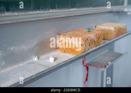 Pezzi di gesso e scacchiera su sfondo verde, vista dall'alto. Foto Stock