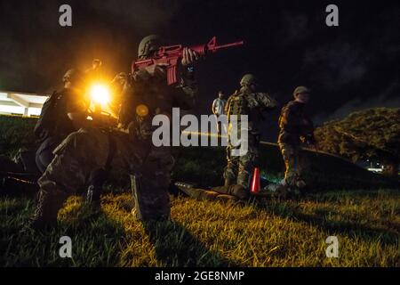 I difensori del 18esimo Squadron delle forze di sicurezza forniscono assistenza alle vittime mentre prendono fuoco simulato durante il volo del difensore della sfida del quartiere sulla base aerea di Kadena, Giappone, 12 agosto 2021. Ogni trimestre il 18° SFS conduce il Defender Challenge per evidenziare gli esecutori superiori per ogni volo, affinare le abilità e aumentare il morale delle unità. (STATI UNITI Air Force foto di Tech. SGT. Michaiah Anthony) Foto Stock