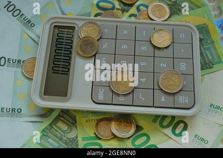 Contando money.Euro bollette e monete.Finanza e risparmio. Cento banconote in euro, calcolatore grigio delle monete in euro. Foto Stock