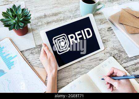 Tecnologia di identificazione a radiofrequenza RFID sullo schermo del dispositivo. Sicurezza e automazione Foto Stock