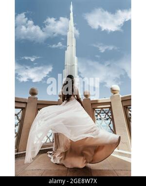 Scatto verticale di una femmina in piedi su un balcone e ammirando una bella torre di Burj Khalifa Foto Stock