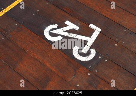 Cartello ciclabile sulla pista ciclabile in legno della città Foto Stock
