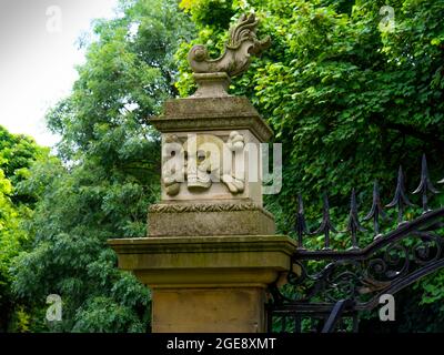 Scultura in pietra raffigurante un cranio e crossoni sul cancello d'ingresso della chiesa di St Cuthberts Kirkleatham North Yorkshire Foto Stock