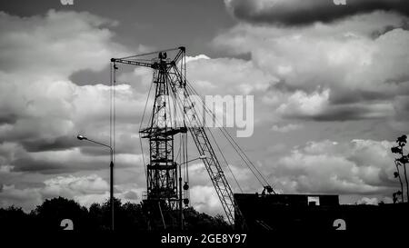 gru da cantiere sullo sfondo di un cielo nuvoloso, monocromatica Foto Stock
