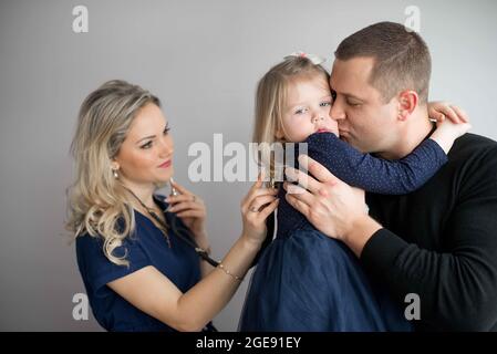 Padre con la ragazza che viene esaminato da pediatra amichevole in clinica Foto Stock