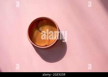 Confezione con cerotto oculare su sfondo rosa. Idrogel rosa macchie per gli occhi trattamenti in bagno. Cura del viso fatta in casa Foto Stock
